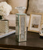 Decorative mirrored candle holder on a table with a blurred background