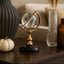 Crystal Globe table deocr  on a shelf with a pumpkin and vase in the background