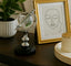 Decorative crystal globe decor on a table with a framed picture and plant in the background