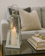Decorative candle lantern on a coffee table with a couch and pillows in the background