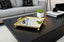 Gold Square Mirror tray on a black coffee table with a plant and books in a living room setting.