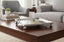 Decorative Silver Square Mirror Tray on a wooden coffee table with a living room setting in the background