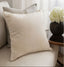 Beige pillow with feathers on a sofa with a blurred background