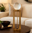 Decorative gold base with a crystal ball on a stand in a living room setting.