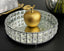 Decorative crystal mirror tray with a gold apple on a black surface