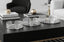 Decorative silver round tray set on a black surface with a modern interior background