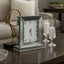 Decorative Mirror clock on a table with candles and a mirror in the background
