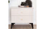Grey bedside table styled with decor books and accessories in modern bedroom setting.