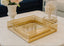 Gold decorative rectangle tray set on a table with floral and coral decorations in the background