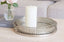 Decorative metal silver tray set with a candle and vase on a table