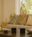 Decorative gold leaf sculpture set on a coffee table in a living room setting.