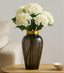 Decorative vase with white flowers on a wooden table against a neutral background