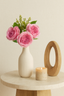 Soft pink artificial rose bunch, 31cm, styled in a white ribbed vase on a round table with a candle.