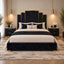 A luxury bed frame with a black velvet upholstered base and a matching multi-tiered headboard accented with gold trim, styled in a modern bedroom with black nightstands, beige bedding, and gold pendant lights.