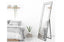 Free standing silver beaded framed mirror styled with bright white bedroom décor.