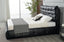 Modern black storage bed styled with pillows and blanket in bedroom