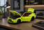 A neon yellow-green scale model of a BMW M2 sports car with its hood and trunk open, displayed on a wooden desk in a modern office setting.