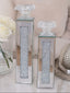 Two decorative candles with crystal embellishments on a light surface.
