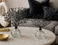 Decorative black crystal tree set on glass bases with a neutral background