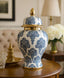 Decorative blue and white patterned vase with gold accents on a wooden table.