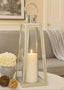 Decorative lantern with a candle on a table in a living room setting.