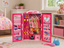 Pink toy wardrobe with dolls and accessories in a child's bedroom