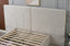 Close up of light grey velvet headboard with modern stitched panel design.