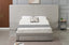 Light grey velvet bed styled with bedding in contemporary bedroom interior.