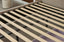 Close-up of Elwood bed’s wooden slat base and storage drawer structure in champagne velvet.