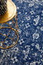 Detailed pattern of Evoke 252 Navy Rug under gold decorative table