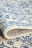 Folded rug edge highlighting plush pile, navy distressed design, and durable woven backing structure.