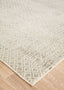 Corner view of Evoke 265 Grey Rug on wooden flooring, showing textured distressed finish.