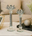 Two decorative candle holders with crystal embellishments on a table.