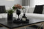 Champagne glass with flowers, and a diffuser on a tray above marble coffee table with a blurred living room background