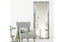 Silver ornate French provincial mirror styled with grey armchair, green cushion and indoor plant.