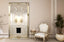 Champagne ornate French provincial mirror styled with armchair and fireplace in elegant interior décor.