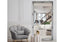 Antique silver French provincial ornate mirror styled with grey chair and modern white interiors.