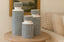 Set of patterned vases on a wooden table with a sofa and framed picture in the background