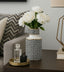 Decorative vase with white flowers on a table next to a couch