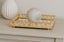 Gold decorative mirror tray with a marble ball on a light wooden surface