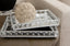 Decorative crystal silver mirror tray set with a spherical decorative item on a couch
