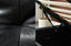 Close up of black leather texture and gas lift storage mechanism details