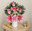 Bouquet of pink flowers in a white vase on a wooden table with a neutral background
