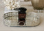 Decorative silver oval tray with a black perfume bottle labeled 'Crystal Noir' on a light surface.