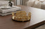 Decorative gold round tray on a wooden table with a blurred background