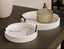 Two white marble-patterned trays with black handles on a dark surface.