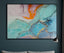 Abstract painting with colorful textures on a dark wall above a sofa.