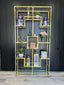 Gold Nelson Bookcase styled with decorative jars, plants, books, and lanterns – a luxurious shelving unit showcasing elegant home décor arrangements.
