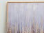 Close-up of gold-framed canvas showing textured gold streaks over a blue and lavender gradient background.