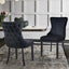 Pair of black velvet Paris dining chairs with tufted backrest in a dining room setup.